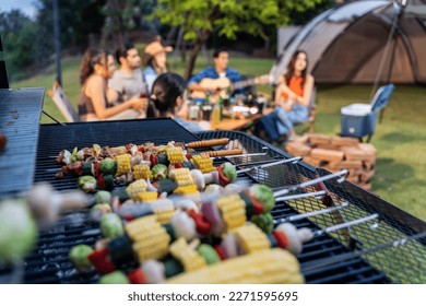 Group of diverse friend having outdoors camping party together in tent. Attractive young man and woman traveler cooking foods barbecue, enjoy hanging out during holiday vacation trip in wood forest. - Shutterstock ID 2271595695