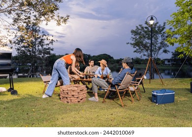 Group of diverse friend having outdoors camping party together in tent. Attractive young man and woman traveler drinking alcohol beer, enjoy hanging out during holiday vacation trip in wood forest. - Powered by Shutterstock