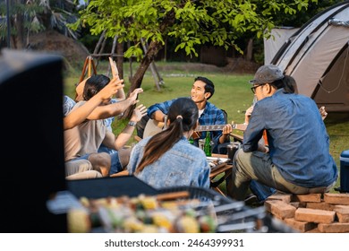 Group of diverse friend having outdoors camping party together in tent. Attractive young man and woman traveler dancing with music, enjoy hangout during holiday vacation trip in nature wood forest. - Powered by Shutterstock