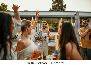 Group of diverse friends dancing and drinking during a pool party in a luxurious villa - Powered by Shutterstock