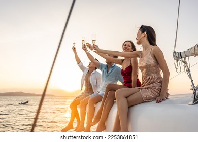 Group of diverse friends drink champagne while having a party in yacht. Attractive young men and women hanging out, celebrating holiday vacation trip while catamaran boat sailing during summer sunset. - Powered by Shutterstock