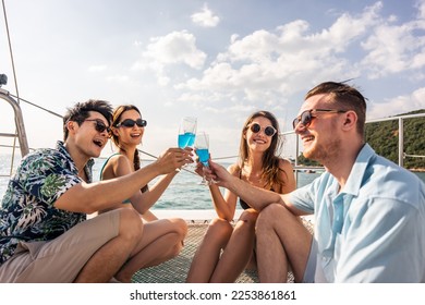 Group of diverse friends drink champagne while having a party in yacht. Attractive young men and women hanging out, celebrating holiday vacation trip while catamaran boat sailing during summer sunset. - Powered by Shutterstock