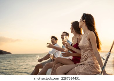 Group of diverse friends drink champagne while having a party in yacht. Attractive young men and women hanging out, celebrating holiday vacation trip while catamaran boat sailing during summer sunset. - Powered by Shutterstock