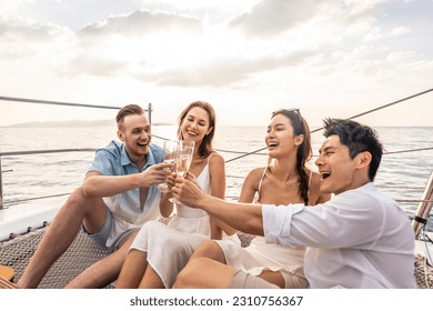 Group of diverse friends drink champagne while having a party in yacht. Attractive young men and women hanging out, celebrating holiday vacation trip while catamaran boat sailing during summer sunset. - Powered by Shutterstock