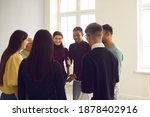 Group of diverse friends gather together in club meeting. Smiling convincing friendly coach talking to team of multiethnic people, suggesting interesting idea, teaching to play funny ice breaker game
