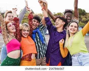 Group of diverse friends holding hands in the air while celebrate success - Powered by Shutterstock