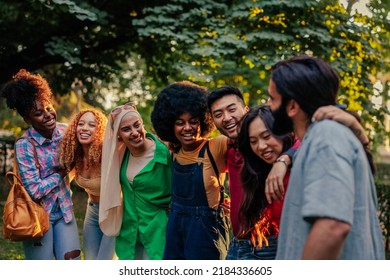 A group of diverse friends are hugging happy to be reunited again after a long time in the city park - Powered by Shutterstock