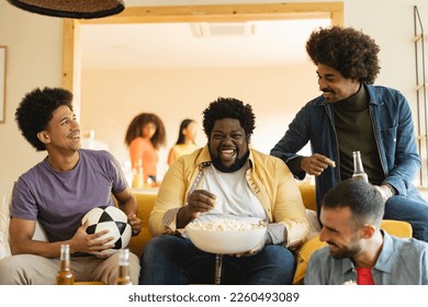 group of diverse friends meet at home on the sofa to watch football game on tv, they are nervous. - Powered by Shutterstock