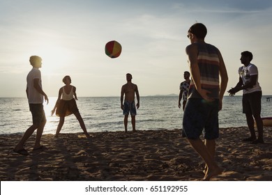 Group of diverse friends playing beach ball together - Powered by Shutterstock