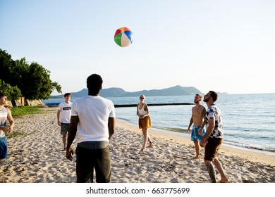 Group of diverse friends playing beach ball together - Powered by Shutterstock