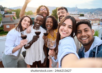 Group of diverse friends taking selfie and having fun at rooftop home party holding glass of red wine. Beautiful young people. Smiling community drinking on outdoor terrace. Positive friendship - Powered by Shutterstock