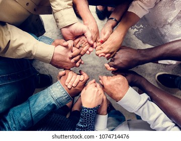 Group of diverse hands holding each other support together teamwork aerial view - Shutterstock ID 1074714476