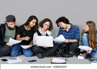 Group Of Diverse High School Students Reading Text Book Tutorial