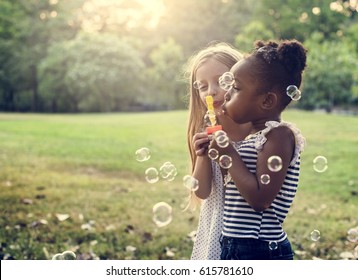 Group of Diverse Kids BLowing Bubbles Together at the Field