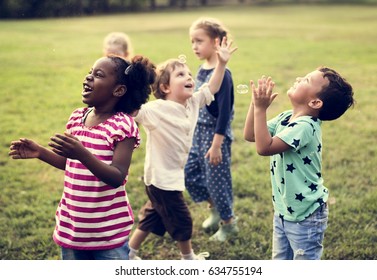 Group Of Diverse Kids Playing At The Field Together