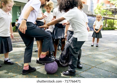 Group Of Diverse Kindergarten Students Playing Soccer Together