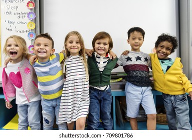 Group Of Diverse Kindergarten Students Standing Together In Classroom