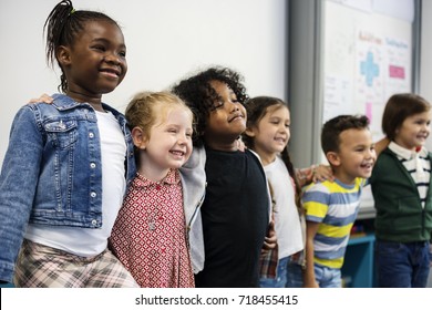 Group Of Diverse Kindergarten Students Standing Together In Classroom