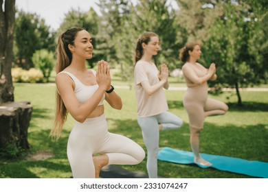 Group of diverse millennial women having group yoga class in a park. Healthy lifestyle. - Powered by Shutterstock