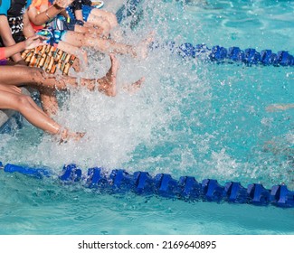 Group of diverse multiethnic children kicking splashing water at poolside of swimming class in North Texas, America. Kids with swimwear at swimming pool class learning to swim - Powered by Shutterstock