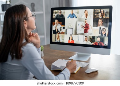 Group of diverse multiracial people on the laptop screen, a young woman is talking with colleagues, employees online. Video conference, brainstorm, webinar concept