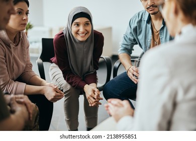 Group Of Diverse People Having Group Meeting With Their Therapist At Mental Health Center. Focus Is On Happy Muslim Woman.