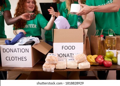 Group Of Diverse People Working In Charitable Foundation, Happy Caucasian And African Volunteers Looking At Donation Box, Separating Donations Stuffs