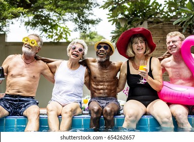 Group of diverse senior adults sitting by the pool enjoying summer together - Powered by Shutterstock