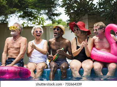 Group of diverse senior adults sitting by the pool enjoying summer together - Powered by Shutterstock