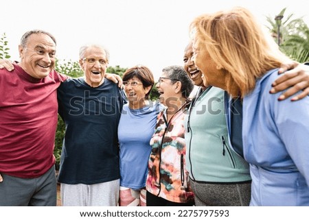 Group of diverse senior friends having fun after workout session at park
