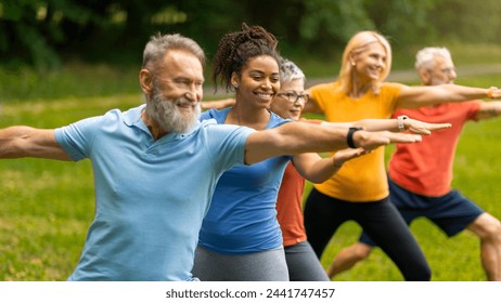 Group of diverse seniors led by young instructor practicing warrior yoga pose outdoors, happy elderly people promoting inclusivity and wellness, exercising in lush park setting, closeup shot - Powered by Shutterstock