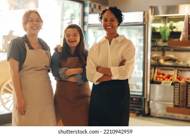 Group Of Diverse Store Workers Smiling At The Camera While Standing Together In A Grocery Store. Three Happy Women Working Together In A Successful Small Business.