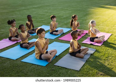 Group of diverse students practicing yoga and meditating sitting on yoga mat in the garden at school. school and education concept - Powered by Shutterstock