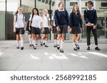 Group of diverse students in school uniform walking together. Diverse high school students smiling and walking in school uniforms at school.