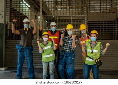 Group Of Diverse Team Of Workers Wearing Face Mask And Protective Helmets Celebrating After Factory Reopen In Front Of The Factory,New Normal Working Concept.