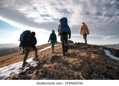 Group Of Diverse Tourists Or Hikers Walks On Mountain Top