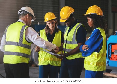 Group of diverse warehouse worker in safety suit, Project manager using blueprint and digital tablet to discussing with engineer team for work in construction industry. Teamwork and unity concept. - Powered by Shutterstock