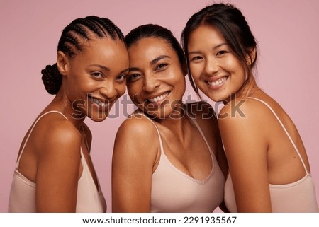 Group of diverse women with different pigmentation .  Multiracial females with glowing skin looking at camera and smiling.