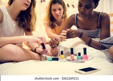 Group of diverse women painting their nails - Powered by Shutterstock