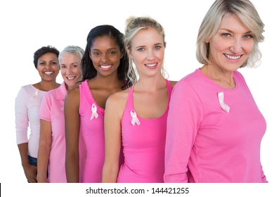 Group of diverse women wearing pink tops and ribbons for breast cance on white background