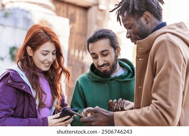 Group of diverse young adults engaged with a smartphone in an urban setting. Multicultural friends sharing digital content, representing modern social connections and technology use in everyday life. - Powered by Shutterstock