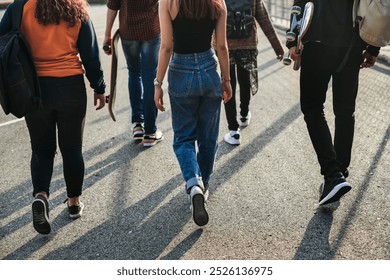 Group of diverse young adults walking together on concrete street. Young adults in casual attire, walking on a street. Diverse group of friends, young adults enjoying a walk on a city street. - Powered by Shutterstock