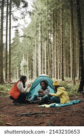 Group of diverse young female friends relaxing together at their campsite in a forest  - Shutterstock ID 2143210653