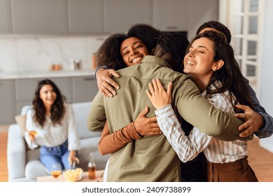 Group of diverse young friends sharing hug during home party gathering at modern apartment interior. Fellow students, men and women, embracing united in laughter and friendship on weekend - Powered by Shutterstock