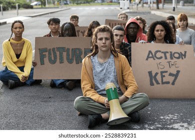 Group of diverse young people participating in a sit-in protest, holding signs reading "Future" and "Action is the key". Image captures youth activism, unity, and determination for social change - Powered by Shutterstock