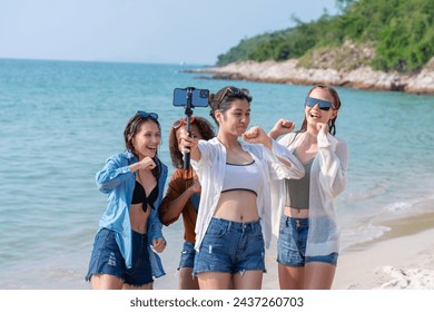 Group of diverse young women taking a selfie with a smartphone on a sunny beach day. Friends Taking Selfie at Beachside. - Powered by Shutterstock