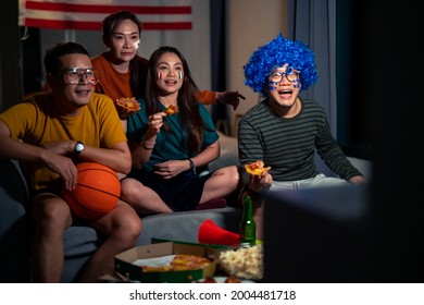 Group of diversity Asian people friends sit on sofa watching and cheering sports game on TV together at night. Excited man and woman sport fans celebrate national sport team victory in sports match - Powered by Shutterstock