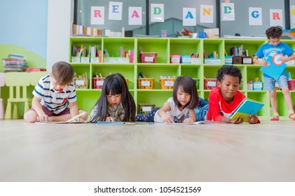 Group of diversity kid lay down on floor and reading tale book in preschool library,Kindergarten school education concept.