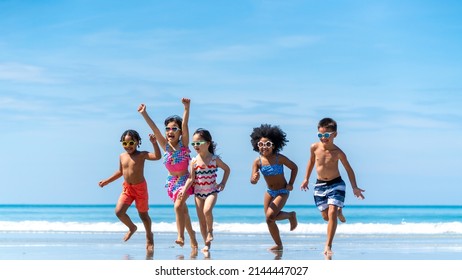 Group Of Diversity Little Child Boy And Girl Friends Running And Playing In Sea Water On Tropical Beach Together On Summer Vacation. Happy Children Kid Enjoy And Fun Outdoor Lifestyle On Beach Holiday