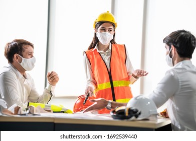 Diversitätsgruppe Ingenieure, die Gesichtsmaske oder chirurgische Maske tragen, wenn sie während der Krise des Ausbruchs von Koronavirus im Büro oder auf Baustellen zusammenkommen oder Arbeiten diskutieren. Engineering Business Concept.